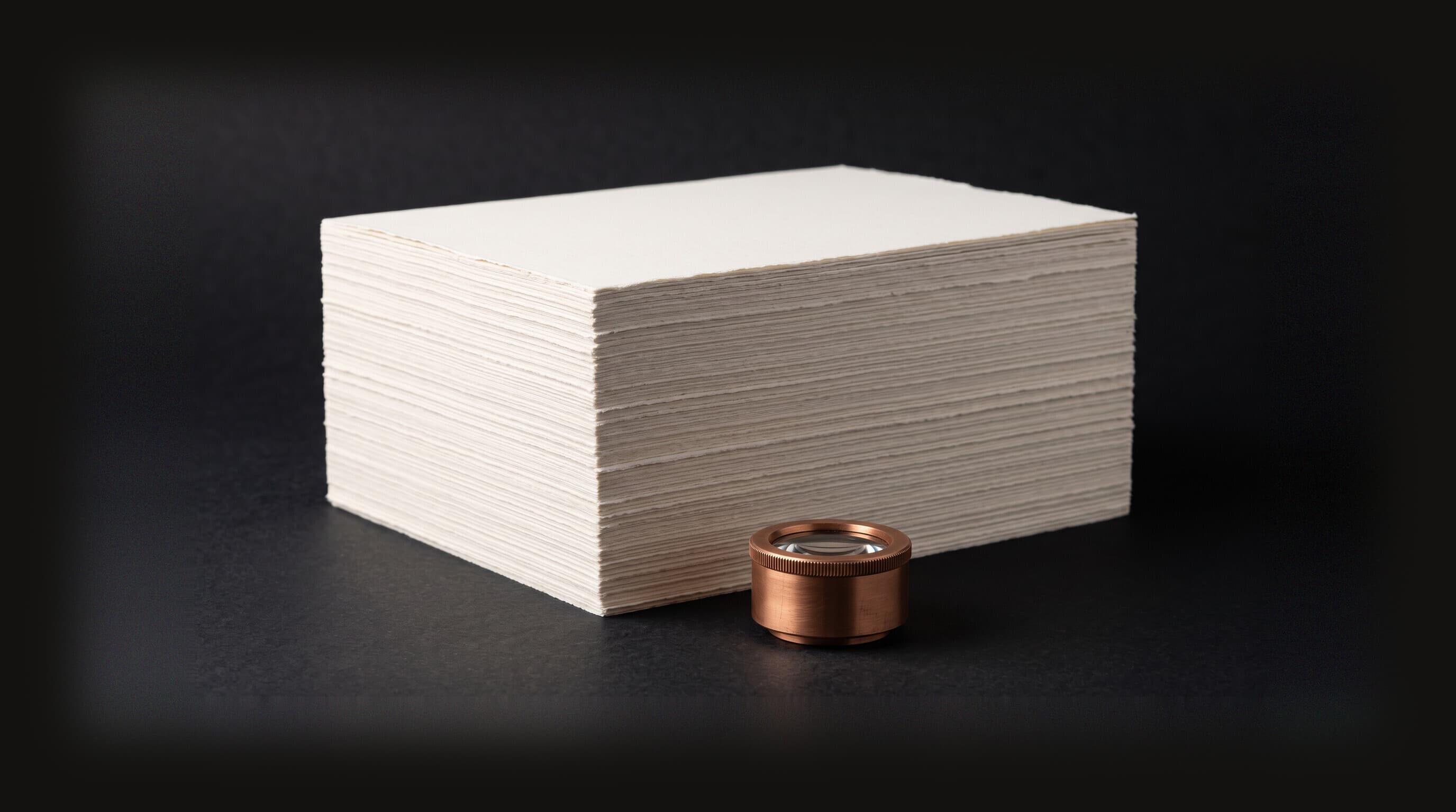 A small copper optical instrument resting at the base of a large stack of blank cream paper, dwarfed by it, representing a model brought to data too heavy to move.